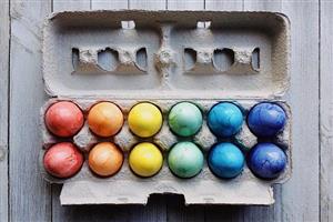 Carton of twelve rainbow-colored eggs.